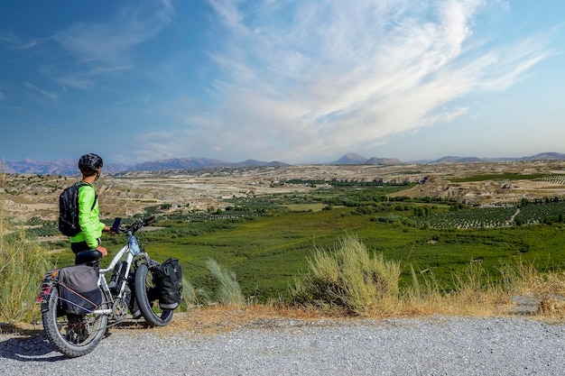 Traveler globetrotter on a bicycle contemplating the landscape