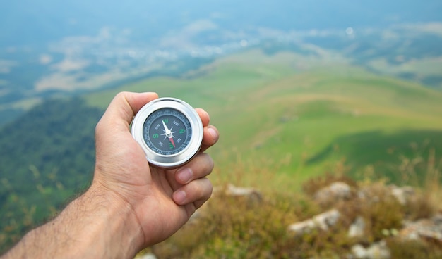 Traveler holding compass in nature background