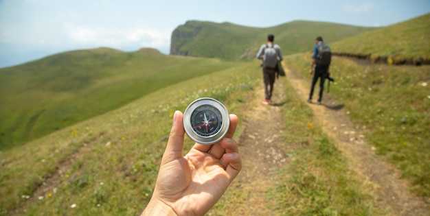 Traveler holding compass in nature background