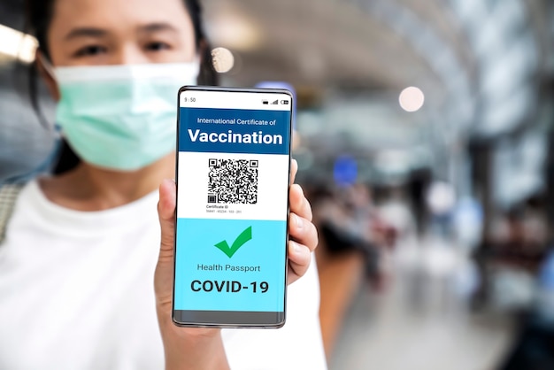 Traveler holds vaccine passport certificate to show COVID 19 vaccination status