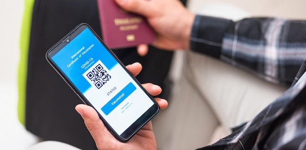 Traveler man holding health passport of vaccination certification on smartphone