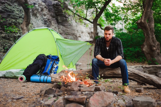 Traveler man relaxing, looking at the fire and dreaming