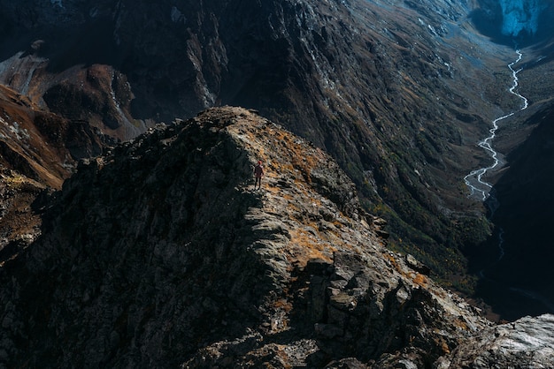 Traveler in the mountains. A man enjoys a beautiful view of the mountains. Man at sunrise in the mountains. A man is traveling in the Caucasus. Hiker at sunset in the mountains. Copy space.