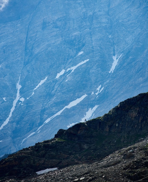 Traveler walking down the rocky mountain