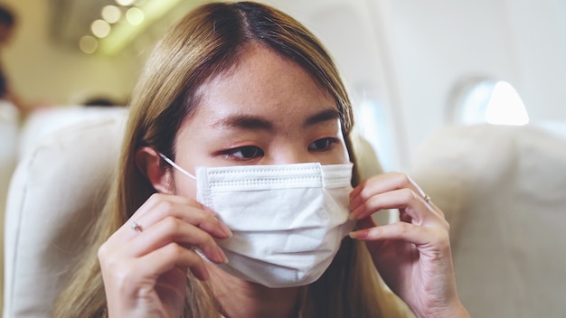 Traveler wearing face mask while traveling on a commercial airplane