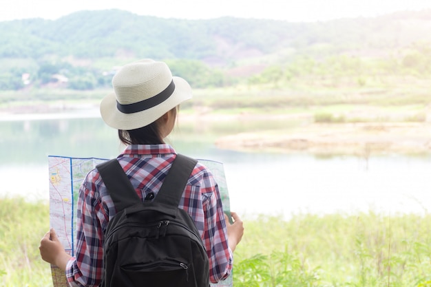 Traveler with map and backpack in morning