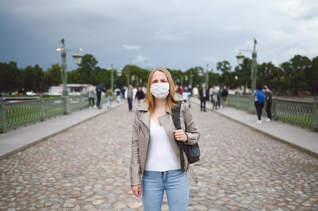 Traveler woman with a backpack and a medical mask