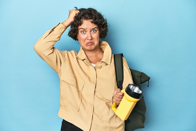 Traveler woman with vintage camera and flashlight being shocked she has remembered important meeting