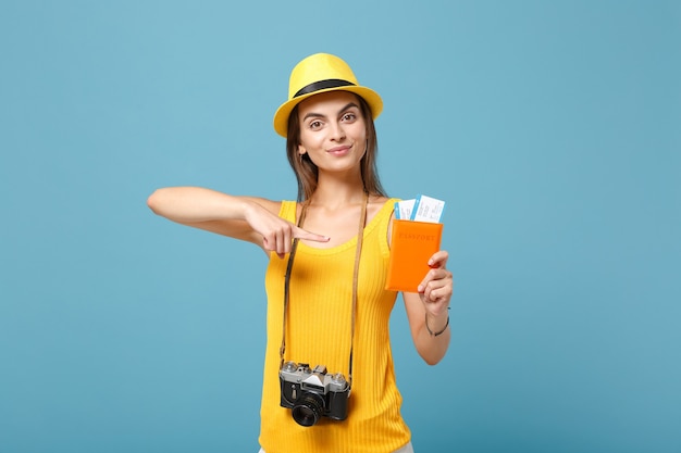 Traveler woman in yellow summer casual clothes and hat holding tickets camera on blue