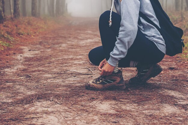 traveler women walking on road in the forest paths in the woods and foggy