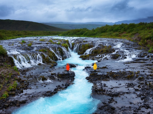 Travelers on Bruarfoss waterfall Iceland Famouns place in Iceland Fast river and cascades Natural landscape at the summer Travel image