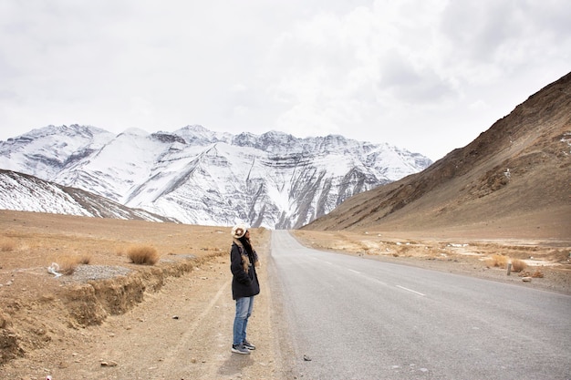 Travelers thai woman travel visit and posing for take photo with landscape high range mountain on Srinagar Leh Ladakh highway at Leh Ladakh village in Jammu and Kashmir India at winter season