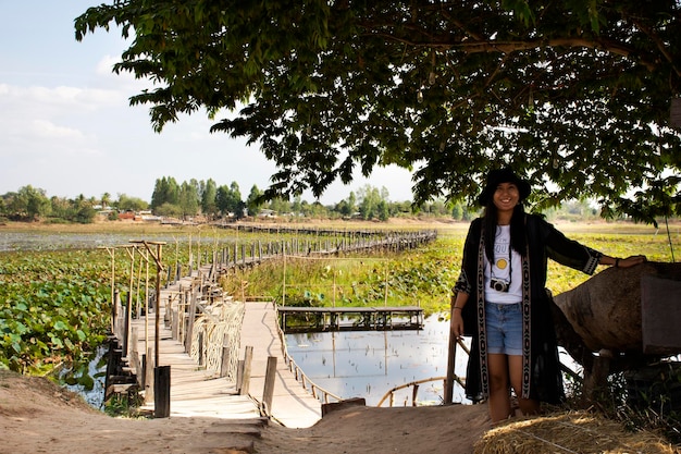 Travelers thai women people travel visit and posing portrait for take photo at Kae Dam long wood bridge at rural on January 11 2019 in Maha Sarakham Thailand