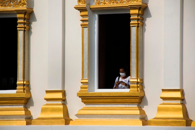 Travelers thai women people travel visit and respect praying buddha blessing holy worship in ancient architecture antique building white ubosot church at Wat Tanot temple in Nonthaburi Thailand