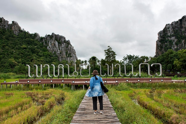 Travelers thai women walking travel visit on walkway wooden bridge in rice field of landmarks KaoNor KaoKaew Limestone mountains at Banphot Phisai city on October 192020 in Nakhon Sawan Thailand