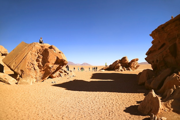 travelers visiting amazing rock formations in eduardo avaroa andean fauna national reserve bolivia