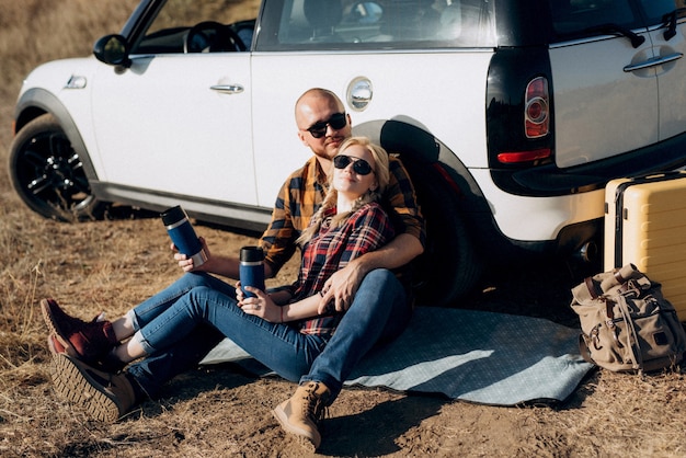 Traveling by car of a young couple of a guy and a girl in plaid shirts