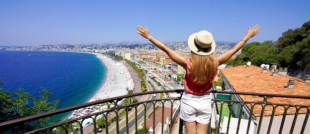 Traveling in France Panoramic view of beautiful girl with open arms on Nice city French Riviera