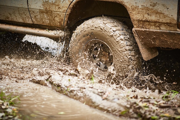 Traveling offroad on a muddy road Closeup of the wheel