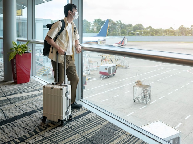 A traveller man is wearing protective mask in International airport