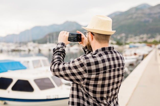 Traveller man taking pictures of luxury yachts marine during sunny day travel and summer concept