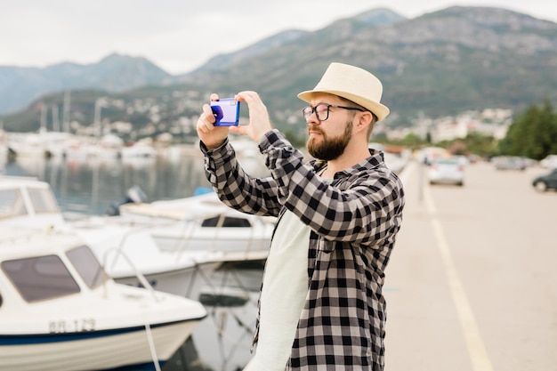 Traveller man taking pictures of luxury yachts marine during sunny day travel and summer concept