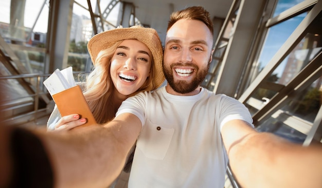 Photo travelling concept couple making selfie at airport terminal