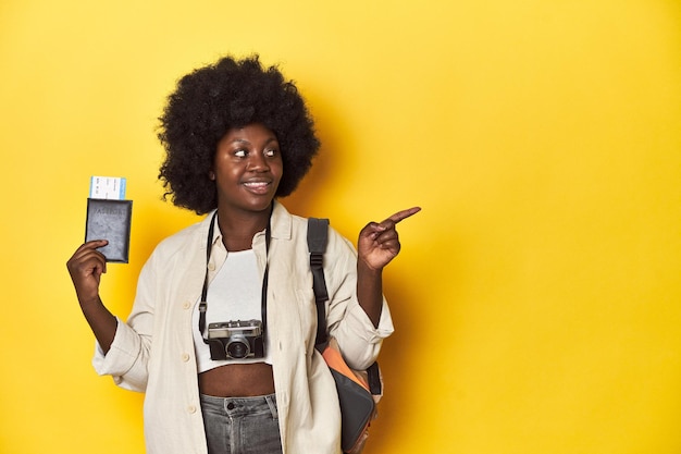 Travelready AfricanAmerican woman holding an airplane ticket on a yellow background