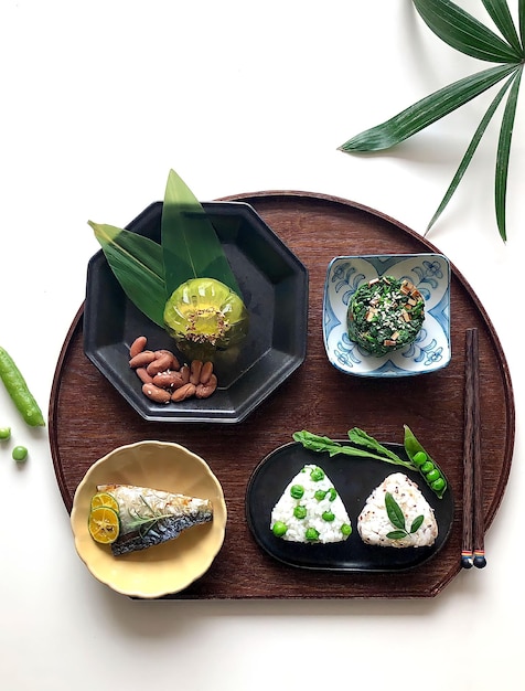 A tray of food including a fish, a plate of vegetables, and a plate of food.