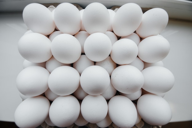 Tray of white fresh eggs close-up on a cardboard