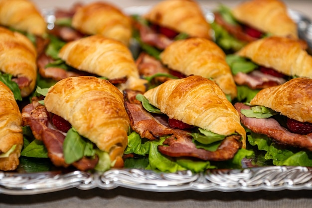 Tray with appetizers pies with salad and meat on the party table close up