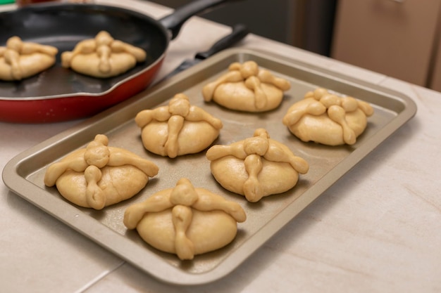 Tray with bread of the dead ready to bake on the counter of a Mexican kitchen