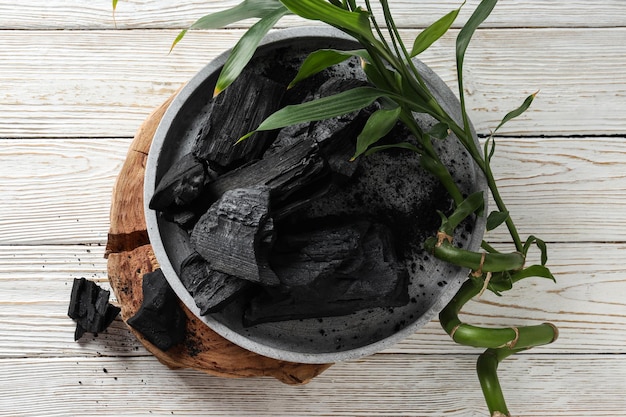 Tray with charcoal on white wooden table top view