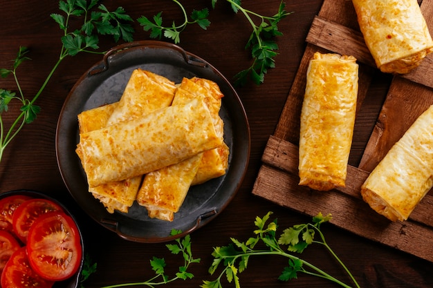 Tray with freshly baked phyllo pasta rolls with tomato