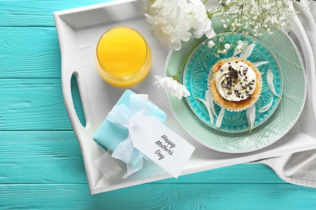 Tray with gift box and tasty breakfast for Mother's day on table