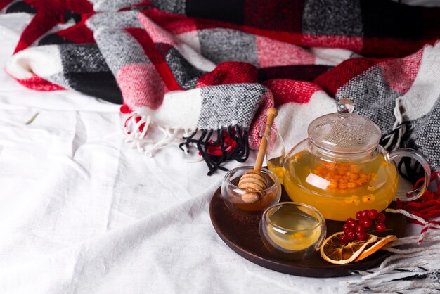 Tray with honey and a cup of hot tea in the bed,