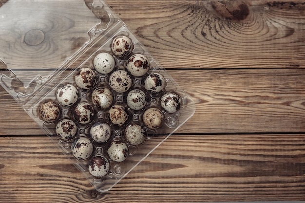 Tray with quail eggs on a wooden table Top view