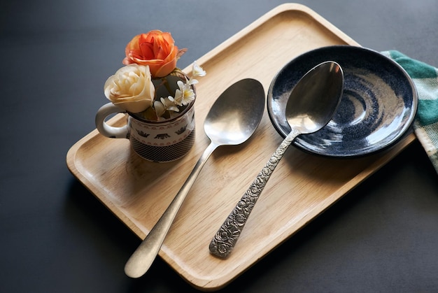 A tray with a spoon and a bowl with flowers on it