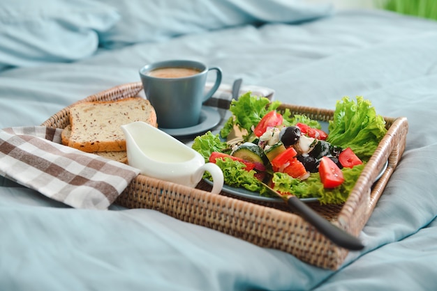 Tray with tasty breakfast on bed