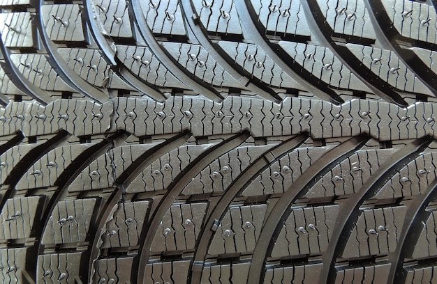 Tread area of new modern car tire with blocks and ribs close up