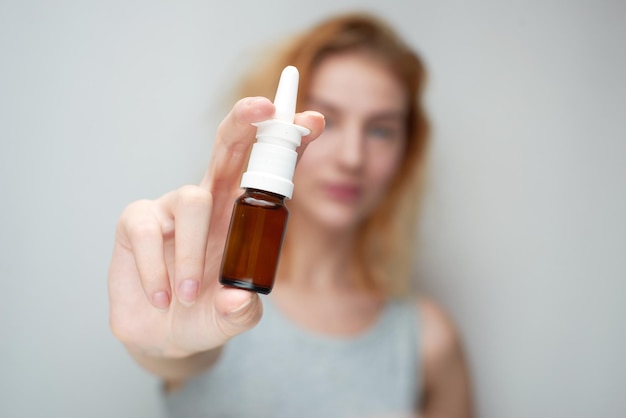 Treatment of a cold, the girl is holding a drop in hand