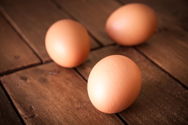 Tree fresh eggs on a rustic wooden board background