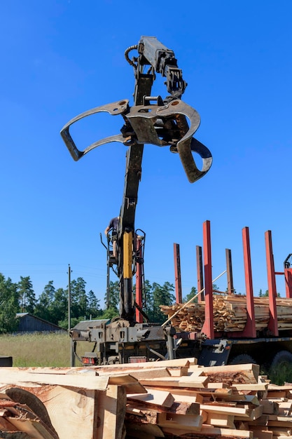 Tree log hydraulic manipulator Load boards supplied to the construction site with a crane manipulator