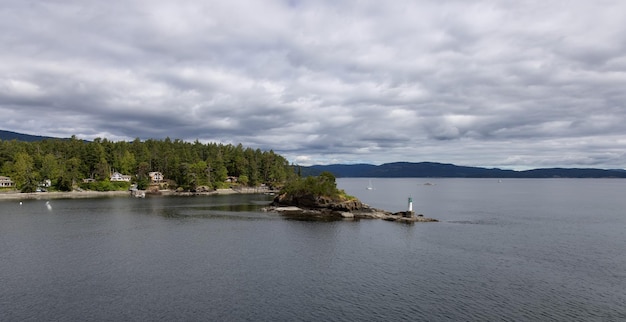 Treed Island with Homes boats and docks nearby smaller island with lighthouse