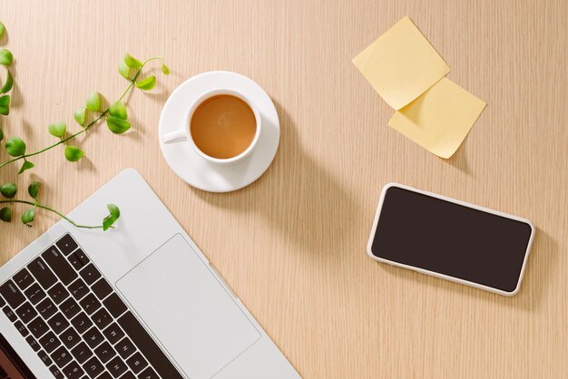 Trendy feminine home office workspace. White office desk. Laptop, coffee cup and phone, notebook, pencil. Flat lay, top view, copy space