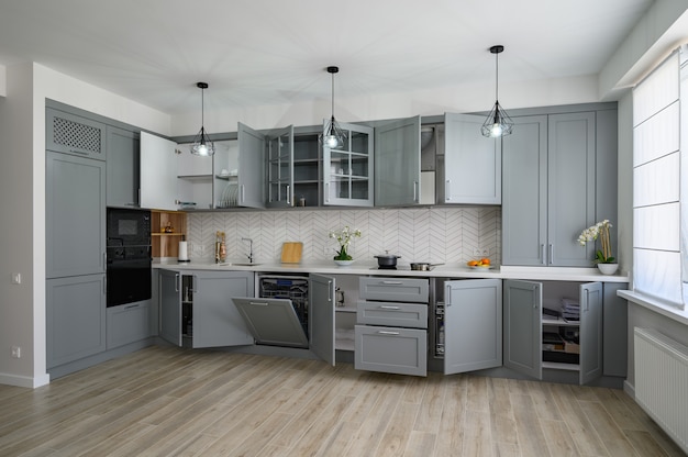 Trendy grey and white modern kitchen furniture with doors open