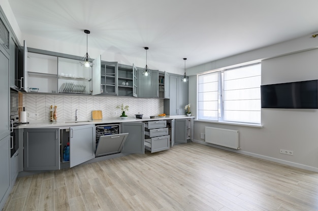 Trendy grey and white modern kitchen furniture with doors open