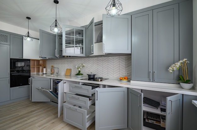 Trendy grey and white modern kitchen furniture with doors open