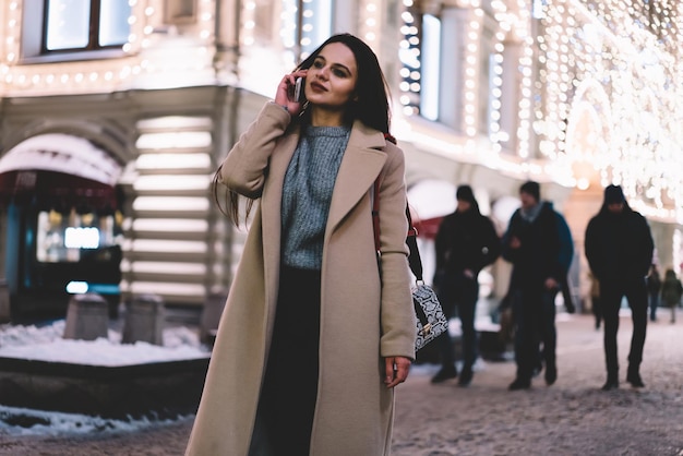 Trendy happy female with phone on winter street