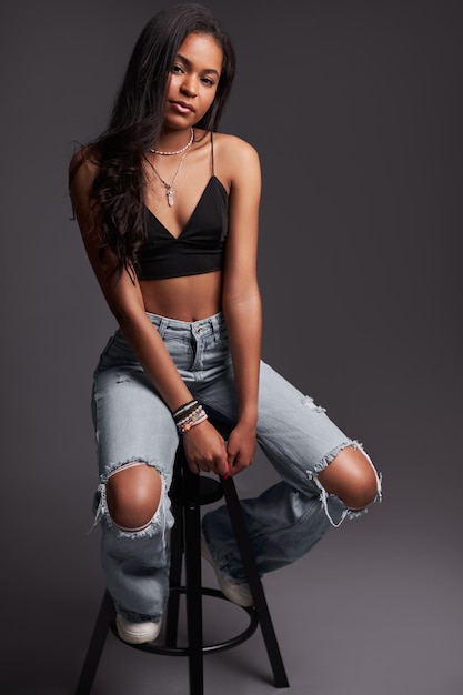 Trendy hispanic female model sitting on stool